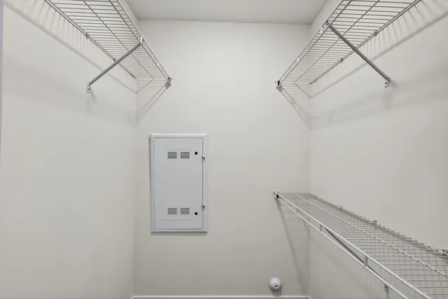 a view of a hallway with wooden floor and a bathroom