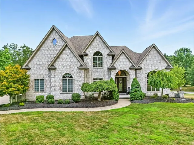 a front view of a house with a yard and potted plants
