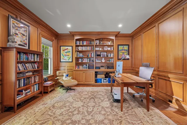 a reading room with furniture book shelf and a rug