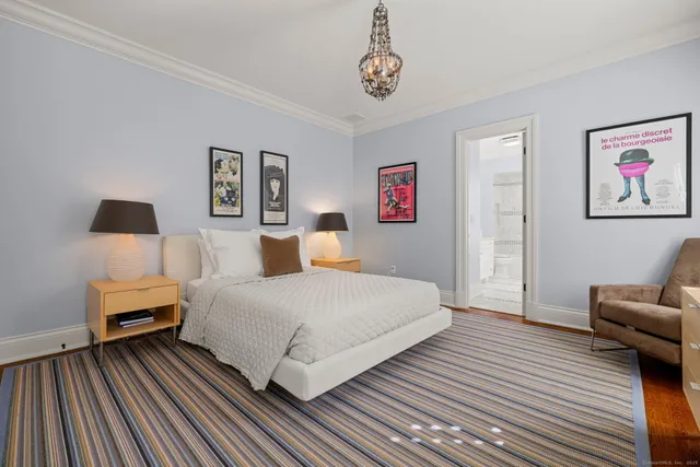 a spacious bedroom with a bed and a chandelier