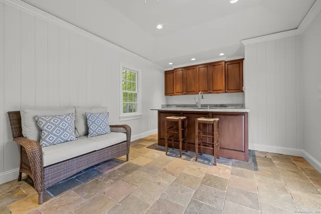 a front view of a house with a yard glass water fountain and sitting area