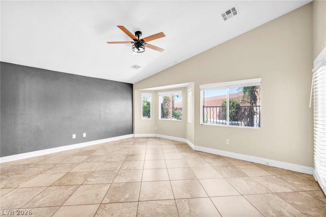 6405 North Raptor Court North Las Vegas, NV 89084 - Photo 8 of 66 A well-lit living space features tiled flooring and bay windows overlooking the outdoors.