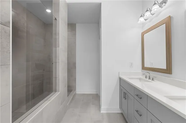 a bathroom with a double vanity sink mirror and shower