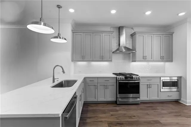 a kitchen with stainless steel appliances a stove a sink and white cabinets