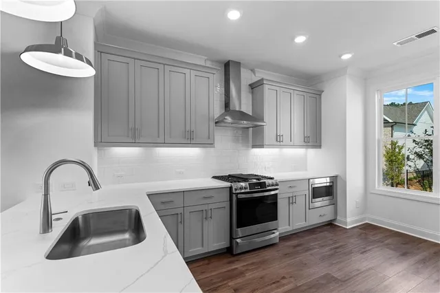 a kitchen with stainless steel appliances a sink stove and cabinets