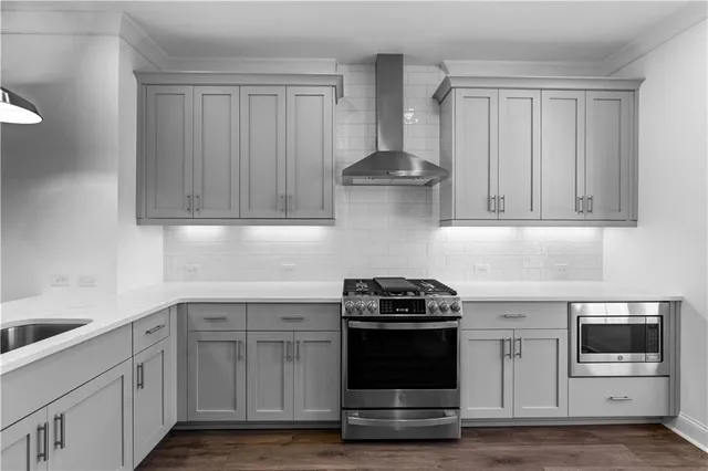 a kitchen with stainless steel appliances granite countertop white cabinets and a stove