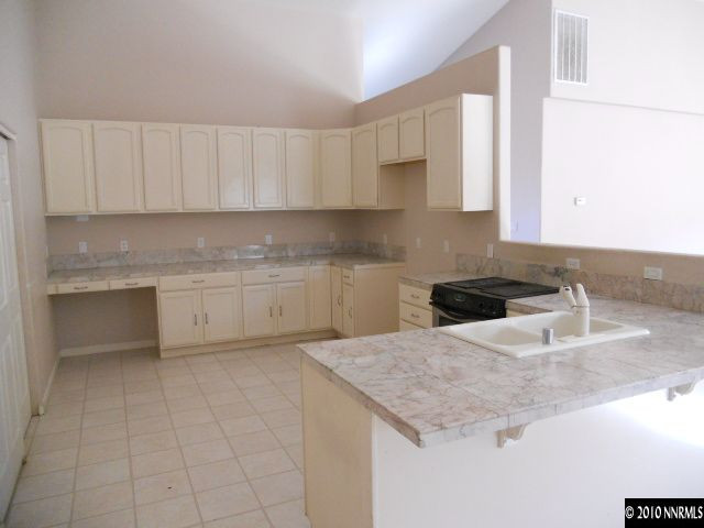 100 John Thomas Lane Reno, NV 89508 - Photo 2 of 13 a kitchen with granite countertop a sink a stove and cabinets