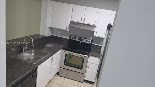a kitchen with granite countertop a sink stove and microwave