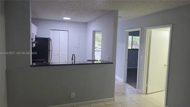 a view of a kitchen with stainless steel appliances wooden floor and a window