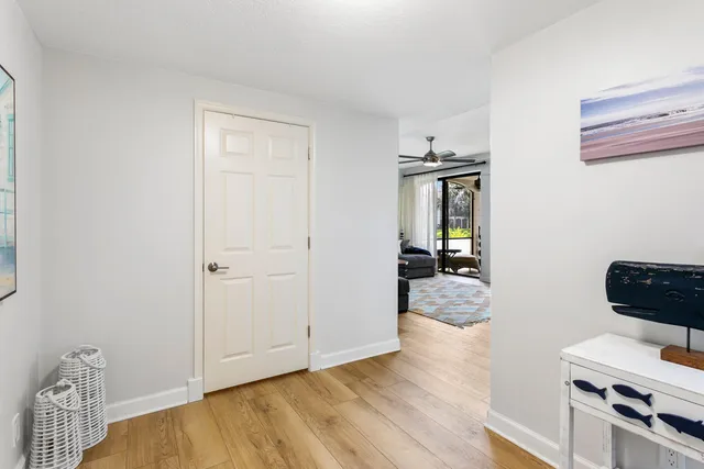 a view of a hallway to room with wooden floor