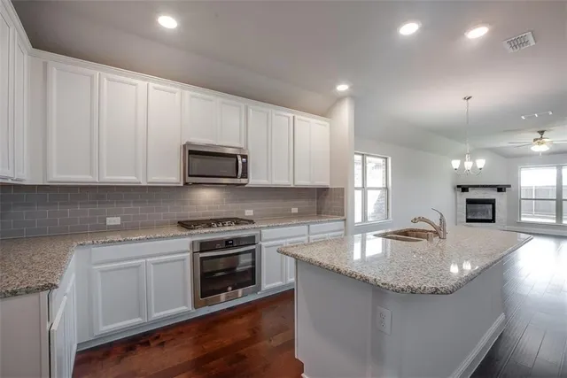 a kitchen with granite countertop a stove and a sink