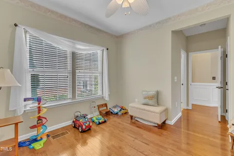 a kitchen with stainless steel appliances granite countertop a refrigerator a microwave oven a stove a dining table and chairs with wooden floor