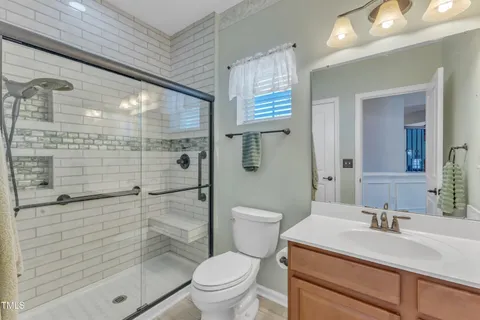 a kitchen with stainless steel appliances granite countertop a stove top oven a sink dishwasher a refrigerator and white cabinets with wooden floor