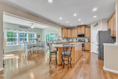 a dining room filled chandelier and wooden floor
