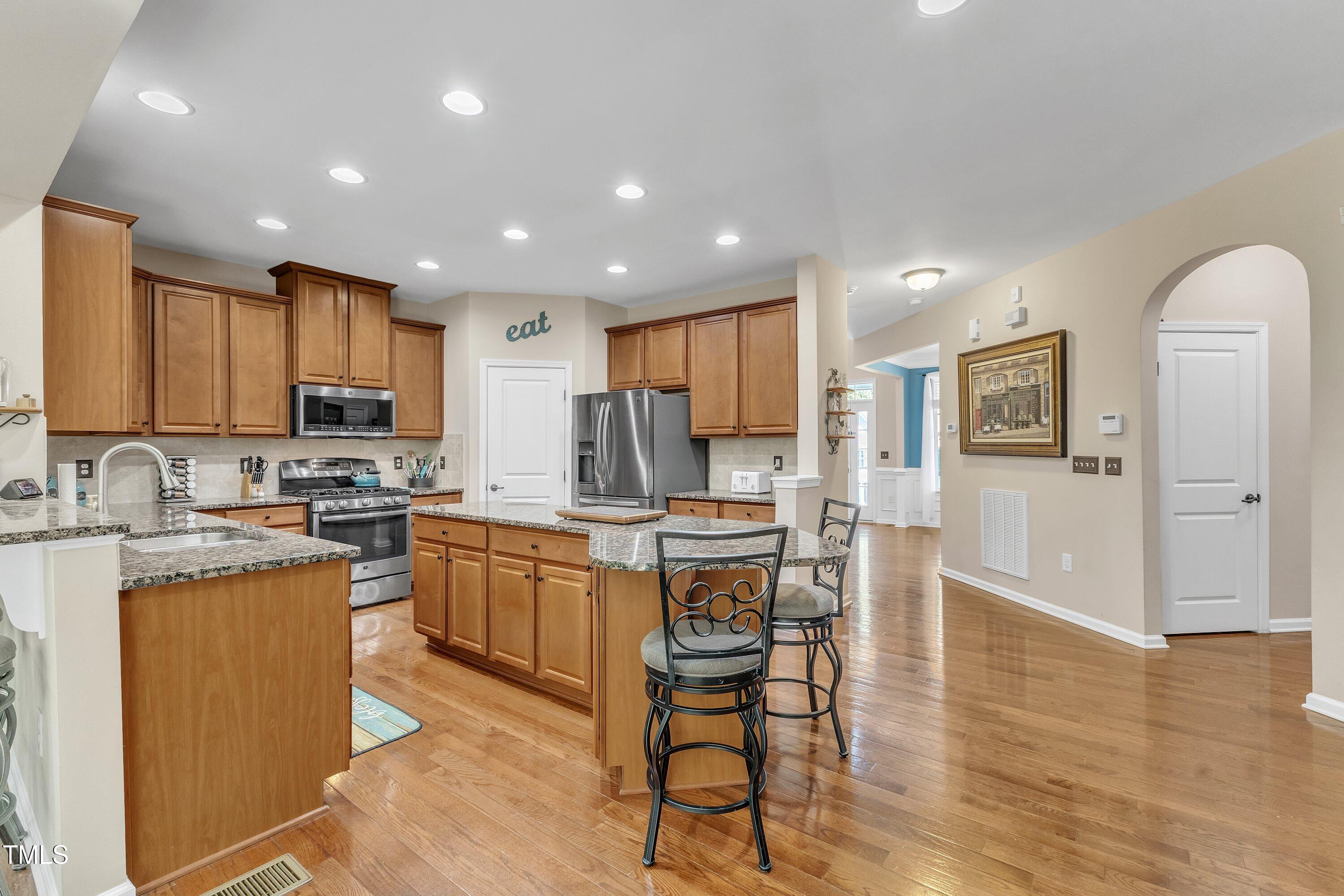 533 Opposition Way Wake Forest, NC 27587 - Photo 26 of 87 a kitchen with stainless steel appliances granite countertop a stove top oven a sink dishwasher a refrigerator and white cabinets with wooden floor