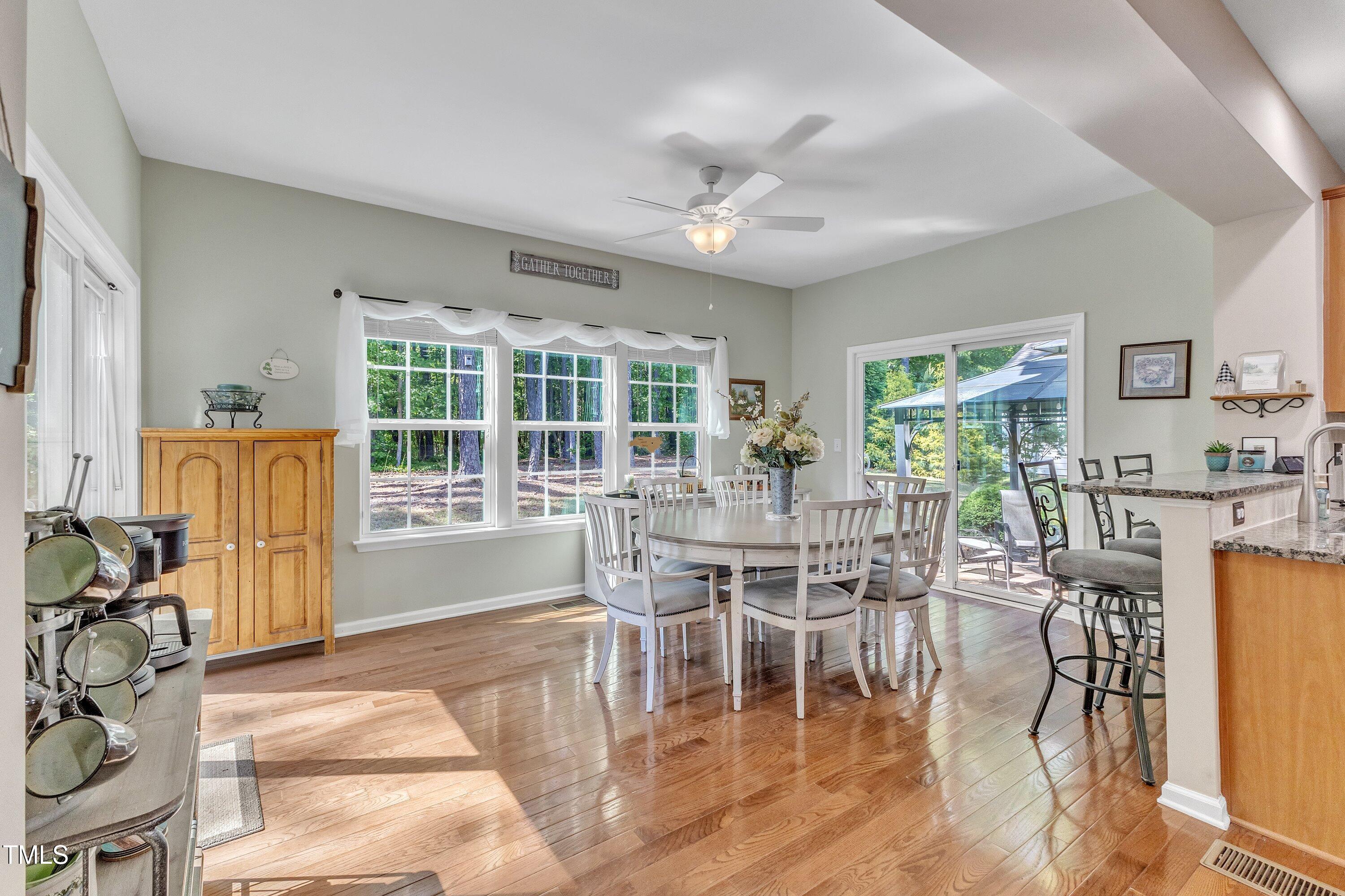 533 Opposition Way Wake Forest, NC 27587 - Photo 30 of 87 a dining room with wooden floor a chandelier a glass table and chairs