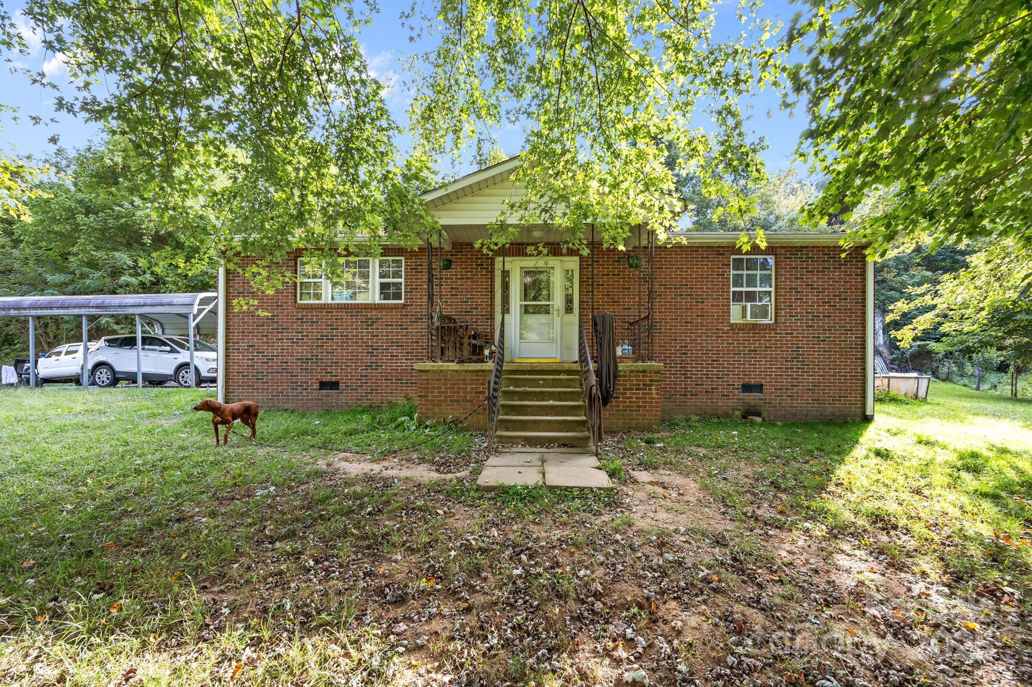 590 Sweet Water Road Marshall, NC 28753 - Photo 2 of 17 a backyard of a house with plants and large tree
