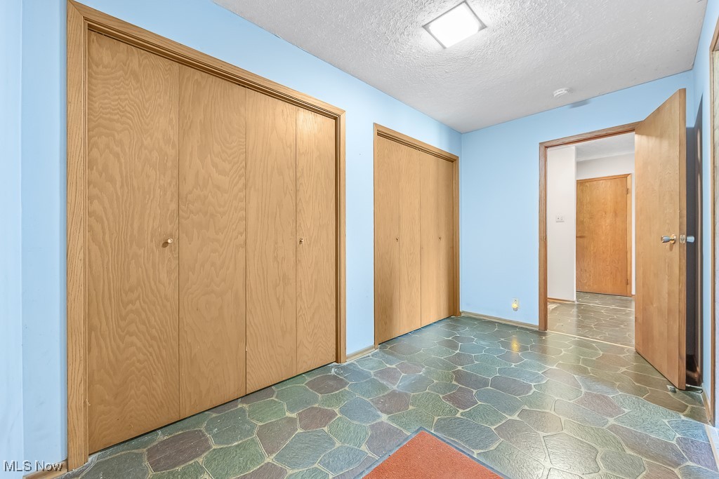 1165 Homeworth Road Alliance, OH 44601 - Photo 19 of 36 Unfurnished bedroom with a textured ceiling and two closets