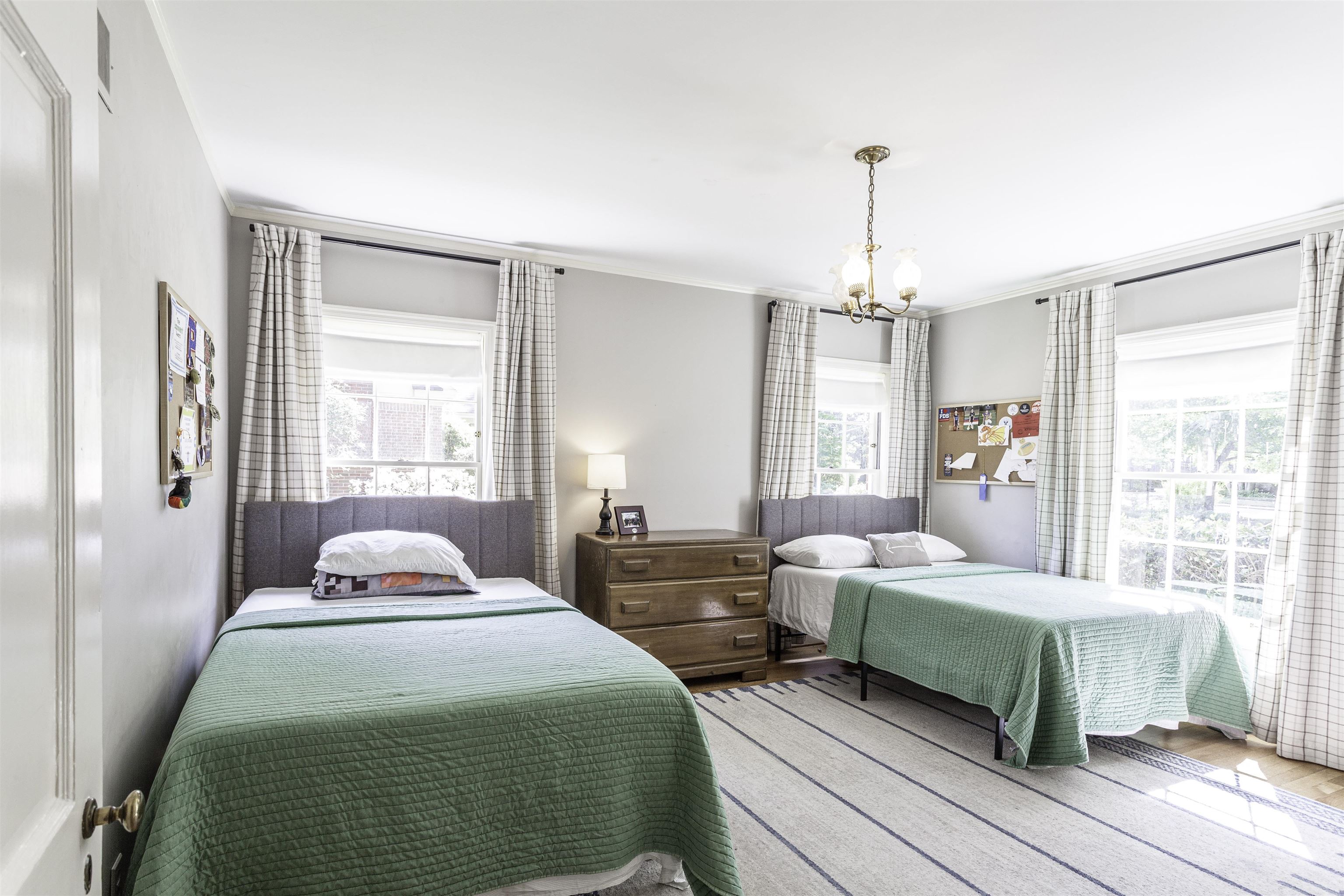 480 Colonial Road Memphis, TN 38117 - Photo 11 of 16 Bright room featuring two windows with plaid drapes, crown molding, a built-in chandelier, and wood-finish flooring