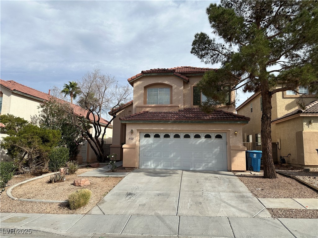 Mediterranean / spanish home featuring a garage, a tiled roof, driveway, and stucco siding