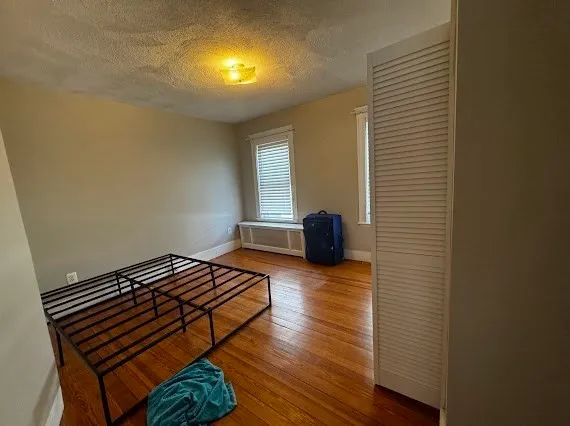 a bedroom with a bed and wooden floor
