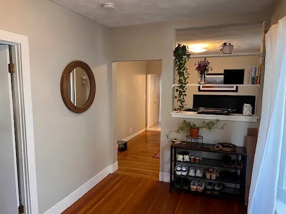 a view of a hallway with wooden floor and utility room