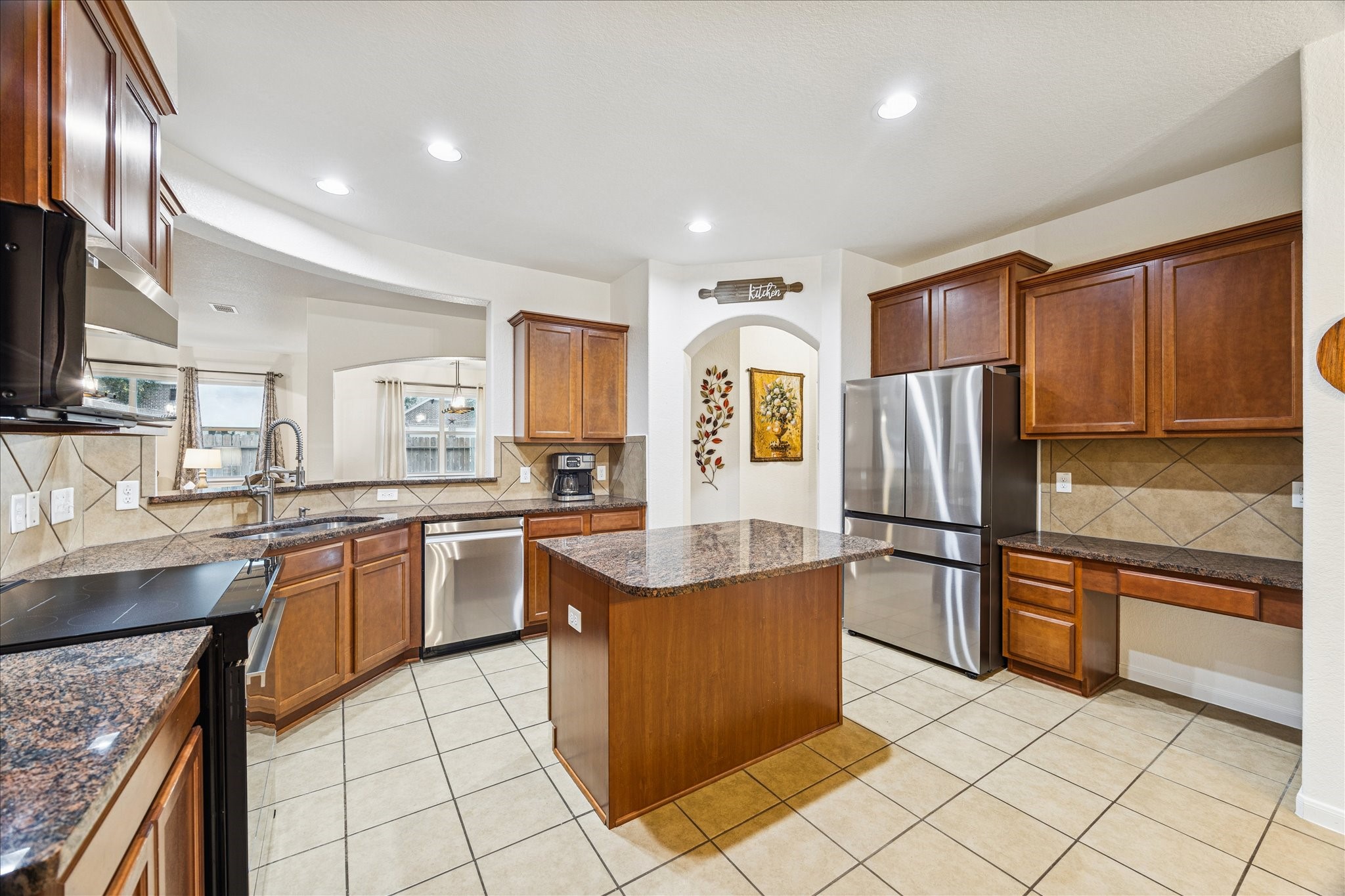 191 Maple Grove Drive Conroe, TX 77384 - Photo 13 of 31 a kitchen with stainless steel appliances granite countertop a refrigerator a sink a stove top oven and a center island
