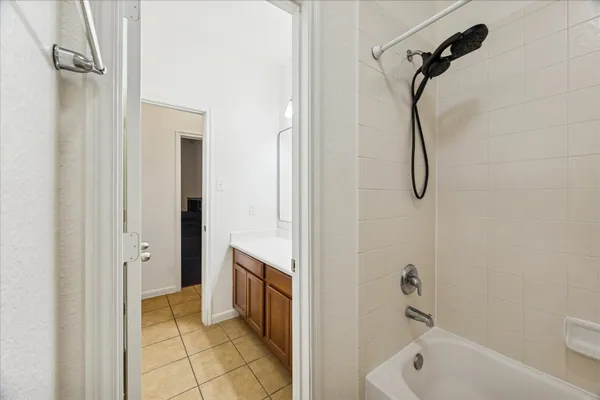 a bathroom with a tub a sink a mirror and a shower