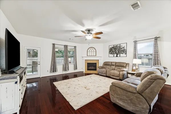 a living room with furniture a fireplace and a flat screen tv