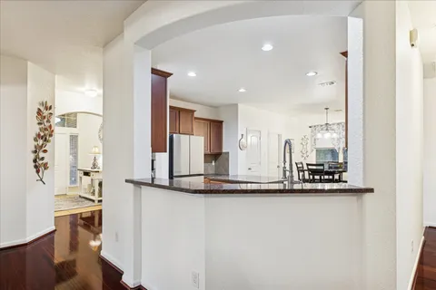 a kitchen with stainless steel appliances granite countertop a sink and a refrigerator