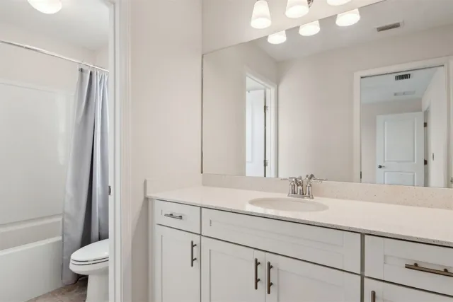 an empty room with a ceiling fan and carpet