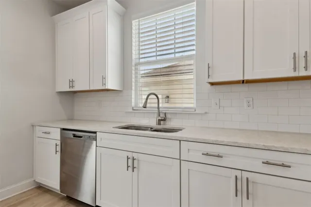 a kitchen with white cabinets and a sink
