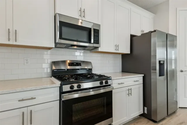 a kitchen with stainless steel appliances a stove a microwave and cabinets
