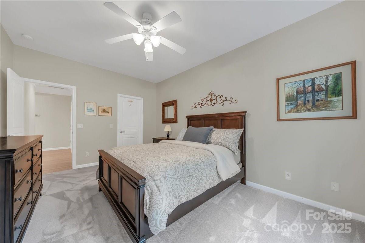 51225 Daffodil Court Fort Mill, SC 29707 - Photo 30 of 45 a spacious bedroom with a bed and a chandelier