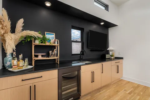 a kitchen with granite countertop white cabinets and black appliances
