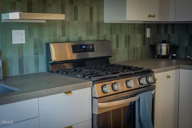 a stove top oven sitting inside of a kitchen