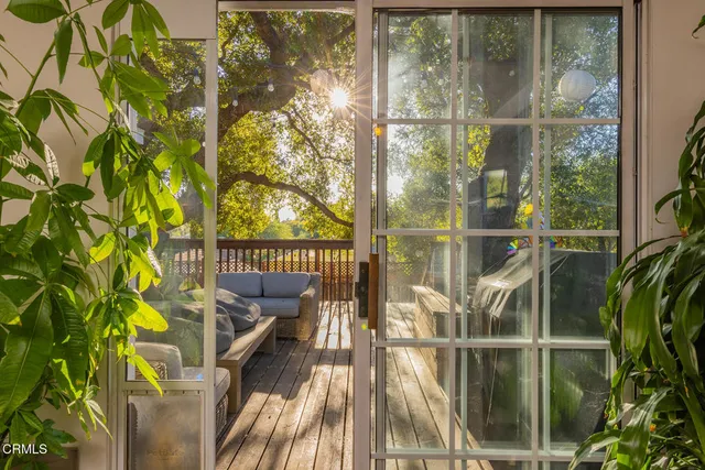 a view of balcony with two large window and wooden floor