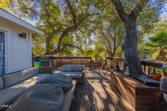a balcony with wooden floor and outdoor seating