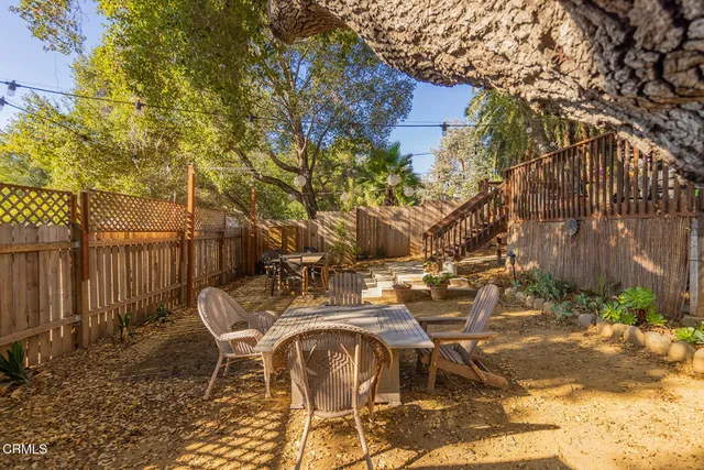 a view of backyard with table and chairs and potted plants
