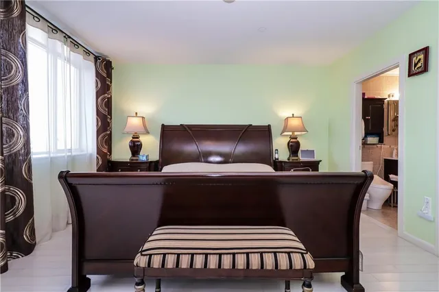 a bedroom with bed couch and window