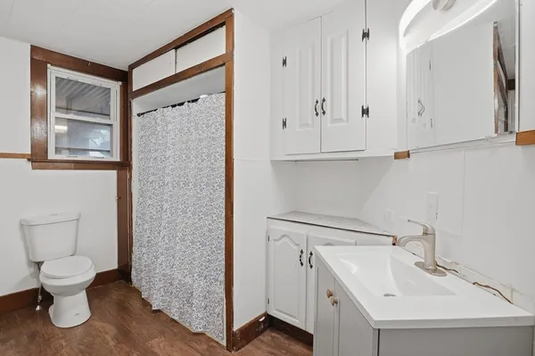 a bathroom with a toilet sink and mirror