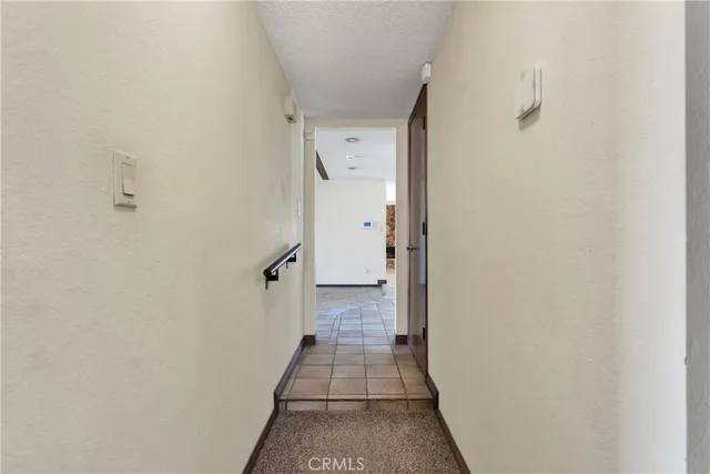 a view of a hallway with wooden floor and a bathroom