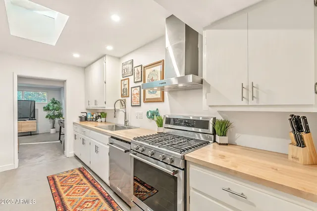 a kitchen with stainless steel appliances granite countertop a stove and white cabinets