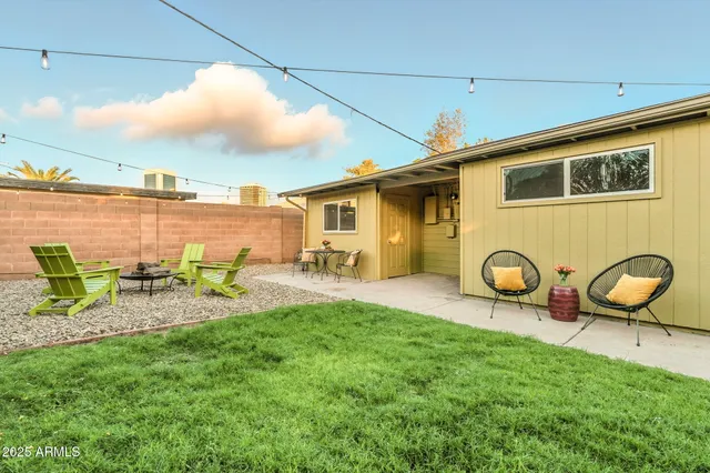 a backyard of a house with table and chairs