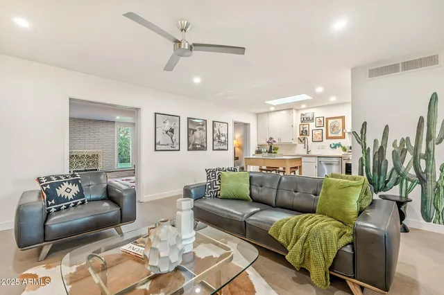 a living room with furniture kitchen view and a large window