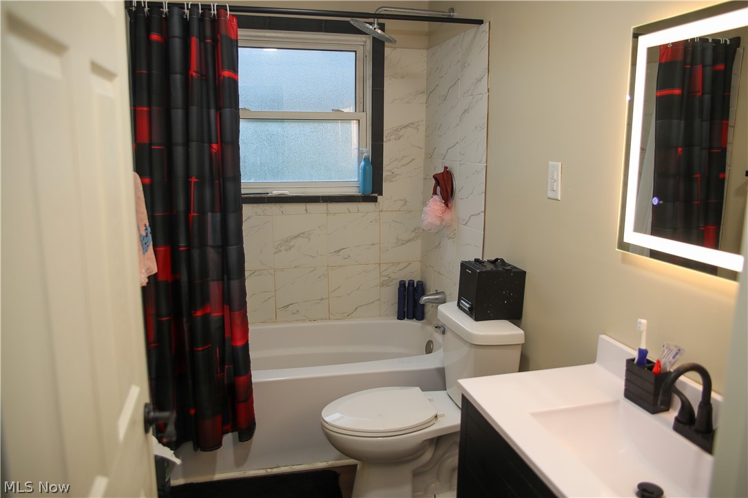 1258 Vane Avenue Akron, OH 44310 - Photo 10 of 12 Bathroom featuring a white bathtub, wall-mounted vanity with integrated sink, and an illuminated mirror