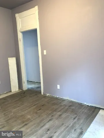 an empty room with wooden floor and closet