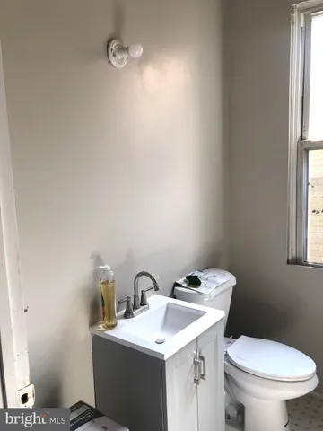 a bathroom with a toilet a sink and mirror