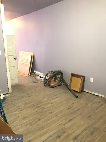 a view of a room with wooden floor and a bathroom