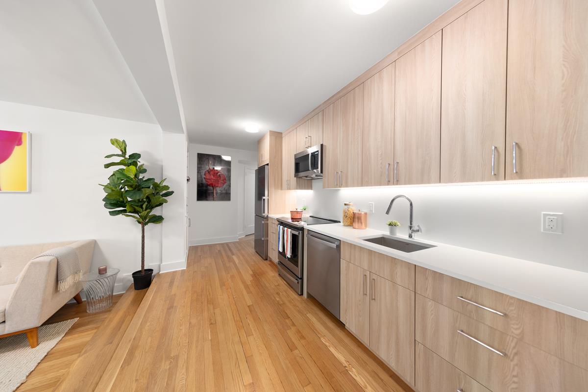 425 Central Park West, Unit 3J Manhattan, NY 10025 - Photo 4 of 9 a kitchen with stainless steel appliances granite countertop a sink dishwasher stove and oven with wooden floor